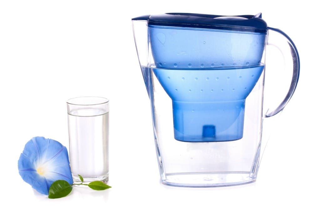 Water filter and a glass over white background
